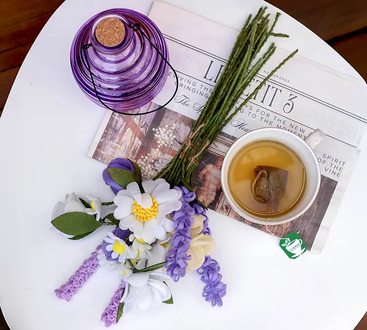 Blomster buket kunstig af stof i flere farver vist på havebord med hvepsefanger