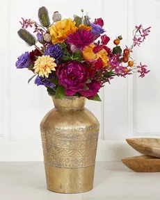 Flot farverig buket af kunstige blomster i guld vase af metal