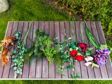 Her er de forskellige kunstige blomster som bl.a. juleroser og grene der er brugt til julebuketten vist.