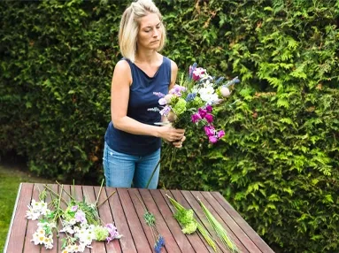 Blomsterbinderen der er i gang med at lave en sommerbuket