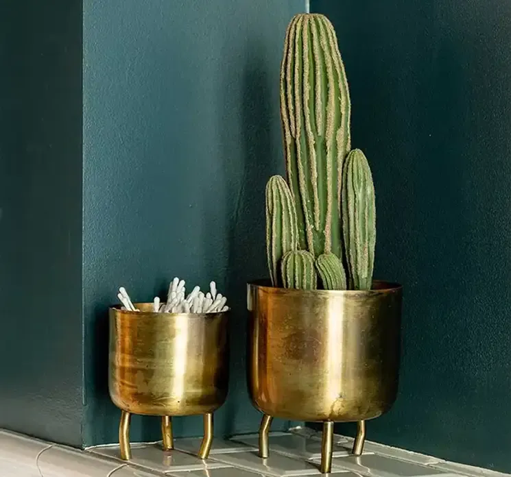 Blomster krukke med fødder af metal i guldfarvet vist på badeværelse med kunstig kaktus og vatpinde