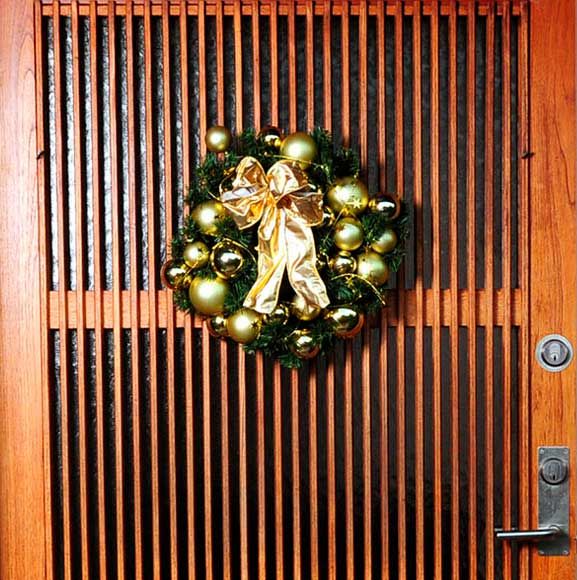 Julekrans på døren med gyldne julekugler og gyldne sløjfe