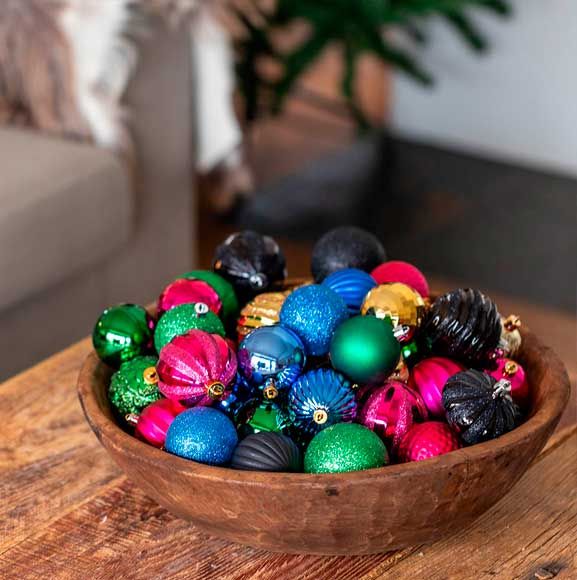 Farverige julekugler i træ skål