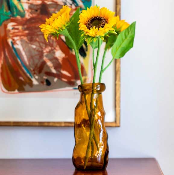 Glasvase i gul med solsikker