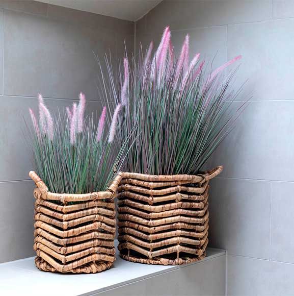 Lyserøse græs i flettet krukke i badeværelset