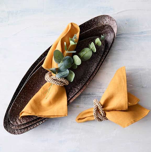 Gule servietter med eucalyptus på messinge fad