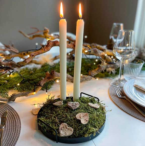 Juleborddekoration med stearinlys og mos