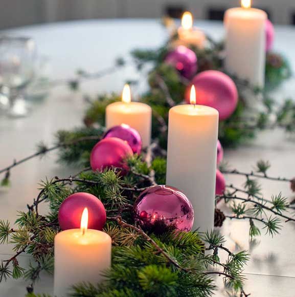 Juleborddekoration med pink julekugler og stearinlys