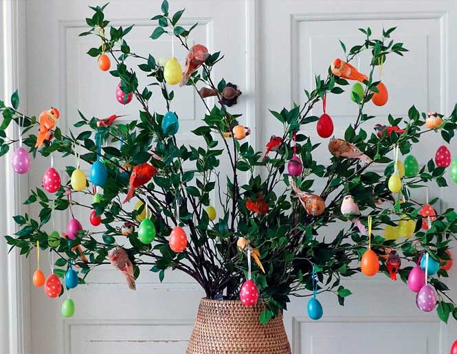 Påske dekoration med påskeæg på grene i flettet vase