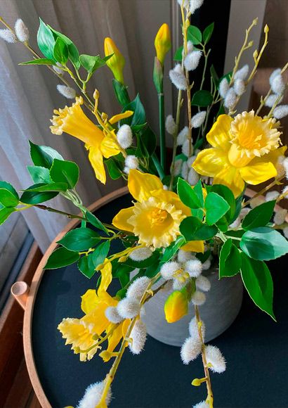 Påskebuket med grønne blader, påskeliljer og gæslinger