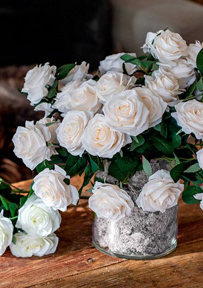 Hvide roser i glas vase med hvid mos