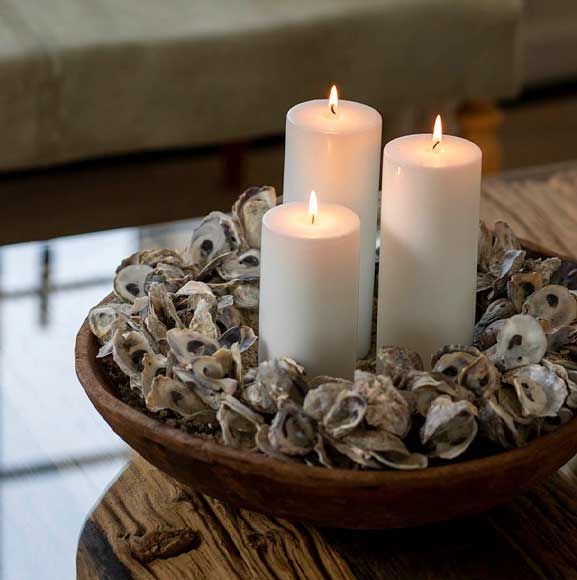 Stearinlys i træskål med strandskaller