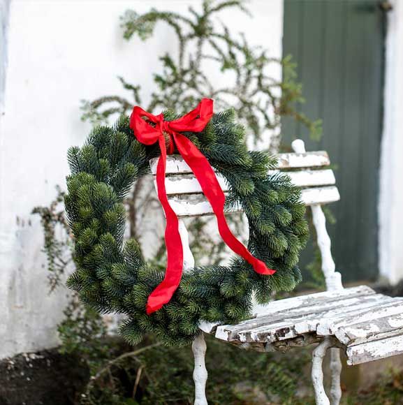 Store krans i gran med rød sløjfe
