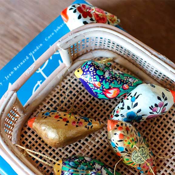 Dekorerede fugle til påaske på flettet fad