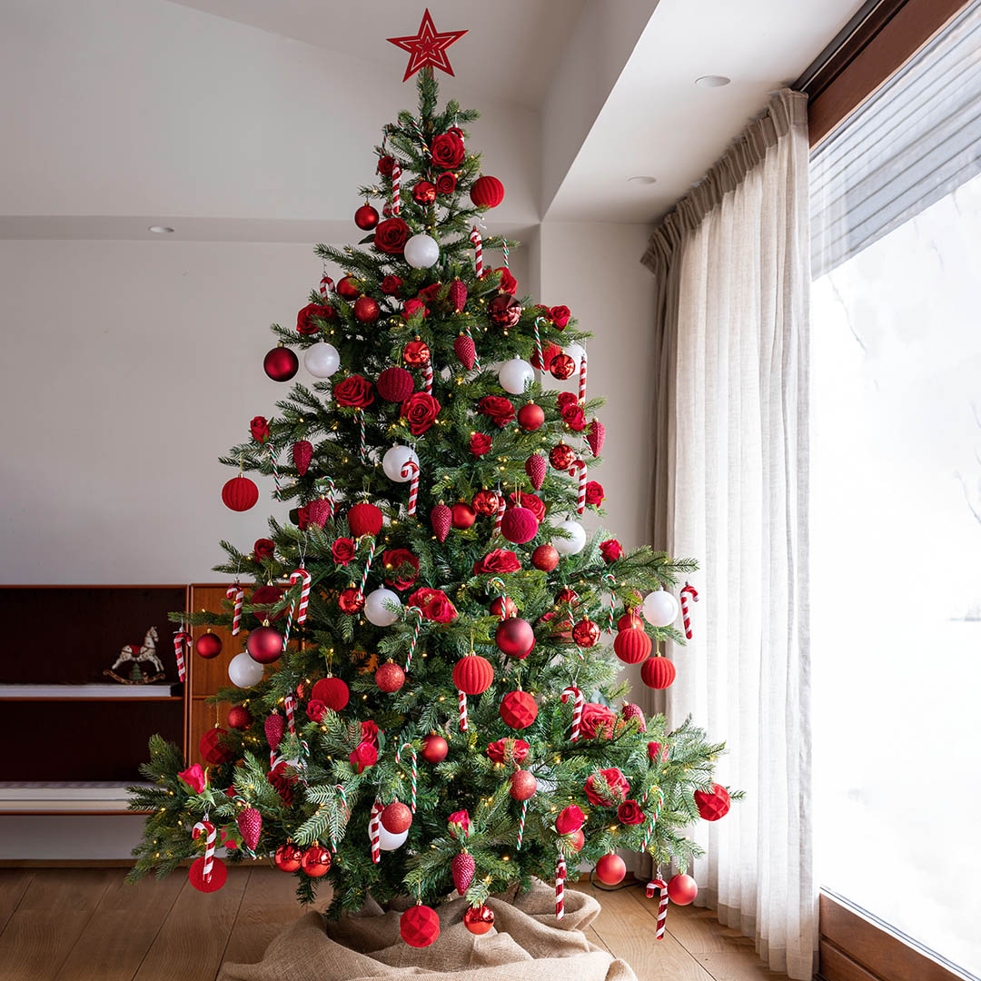 kunstig Grandis grantræ med traditionelt julepynt i røde farver