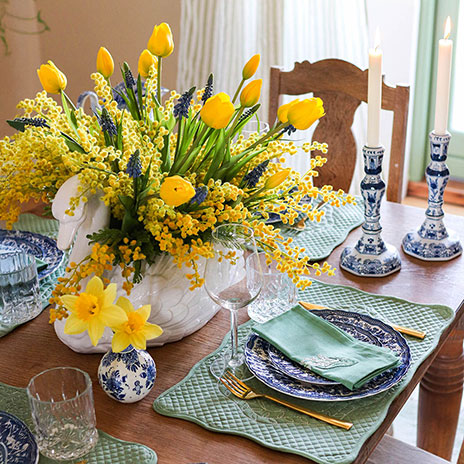 PÅskebord med flot buket i midten af kunstige tulipaner, mimoser og perlehyacinter