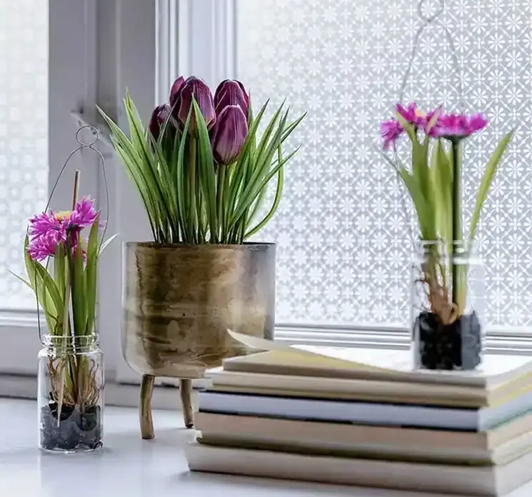 Kunstige marguerit blomster i pink glasvase med ophæng vist i vindueskarm
