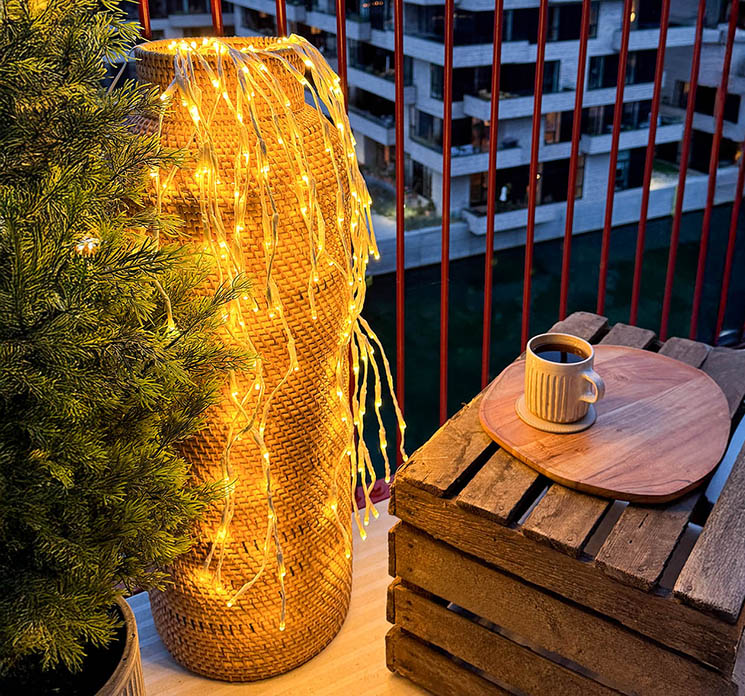LED lyskade kaskade effekt til udendørs og indendørs brug, hvid ledning vist i miljø med høj flettet vase