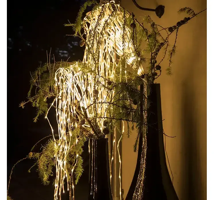 LED lyskade kaskade effekt til udendørs og indendørs brug, hvid ledning vist i miljø med høj vase