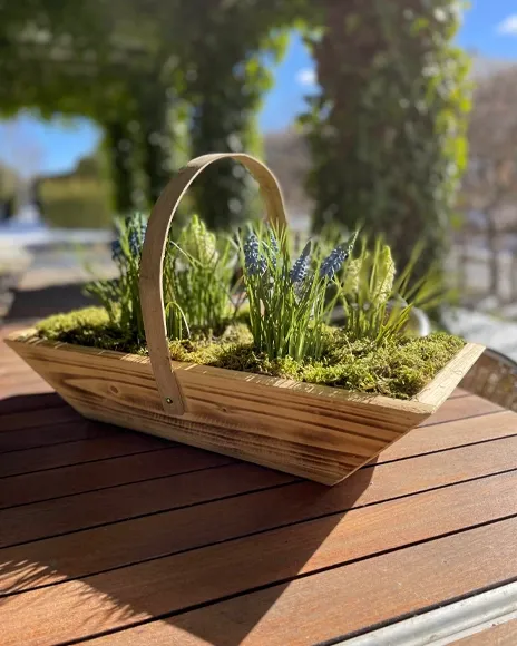 træbakke med hank fyldt med mos og kunstige perlehyacinter