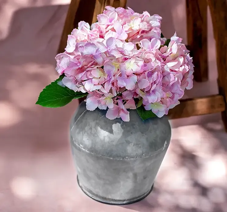 Kunstig hortensia buket af kunstsilke i lyserød vist i miljø med en zink vase