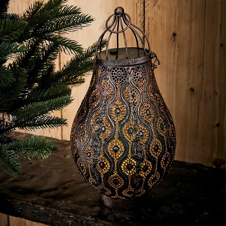 Lanterne i metal og mønster der kaster et smukt lys ud i rummet