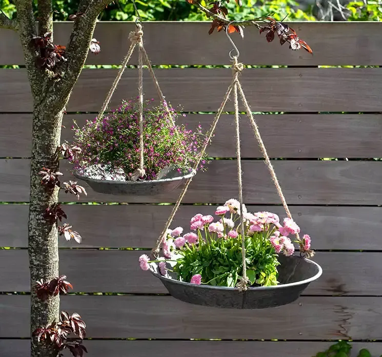 Bakke af mat zink med reb ophæng vist i havemiljø med blomster