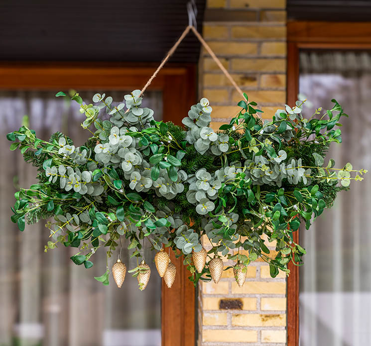 Deko gitter til blomster og plante skyer af metal i sort her vist i udendørsmiljø med kunstige grene og julepynt