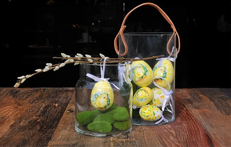 Dekoration med glasvaser der er fyldt med påskeæg og kunstige mossten