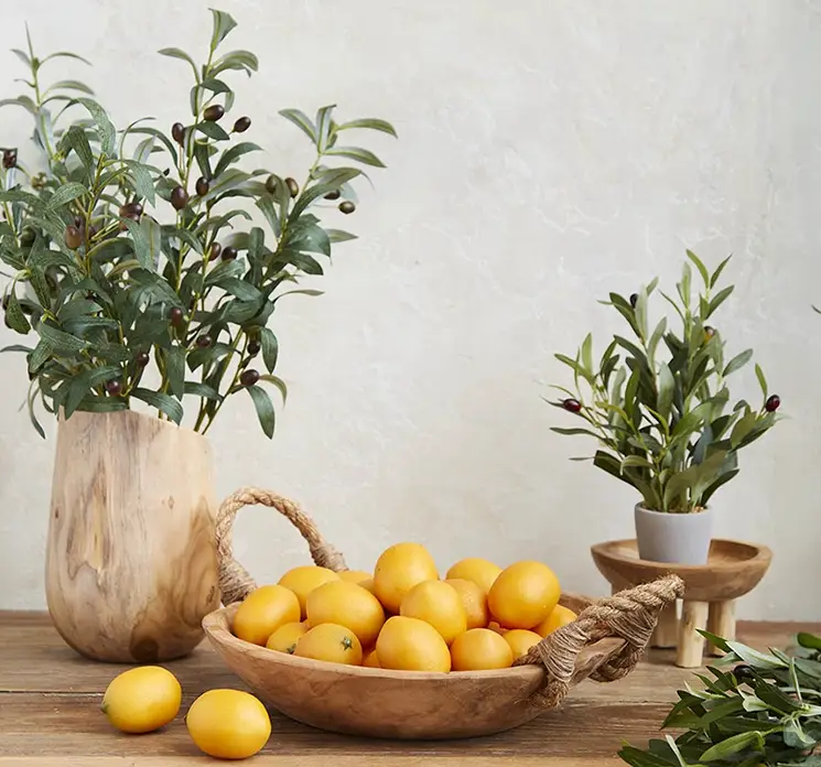 Fad af teaktræ med reb håndtag i naturfarvet vist på bord med kunstige olivengrene og træ, fadet er fyldt med kunstige citroner i køkkenmiljø