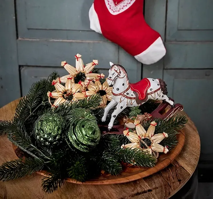 Kunstig gran hænger af plast i grøn vist i træfad med blandet julepynt