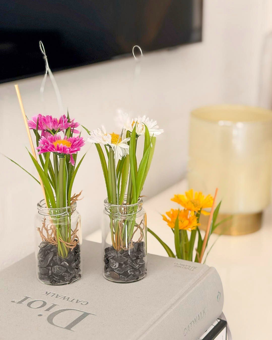 Små detaljer kan gøre overraskende meget 🌼
Kunstige margueritter i små glasvaser med ophæng er en nem måde at tilføre lidt blomsterstemning til hjemmet. Hæng dem i vinduet, på en knage eller lad dem pynte i stuen, hvor de spreder sommerstemning uden vedligeholdelse.
#brøndsholm #kunstigeblomster #margueritter #kunstigmarguerit #boligindretning #sommerstemning #blomsterinspiration #homedecor