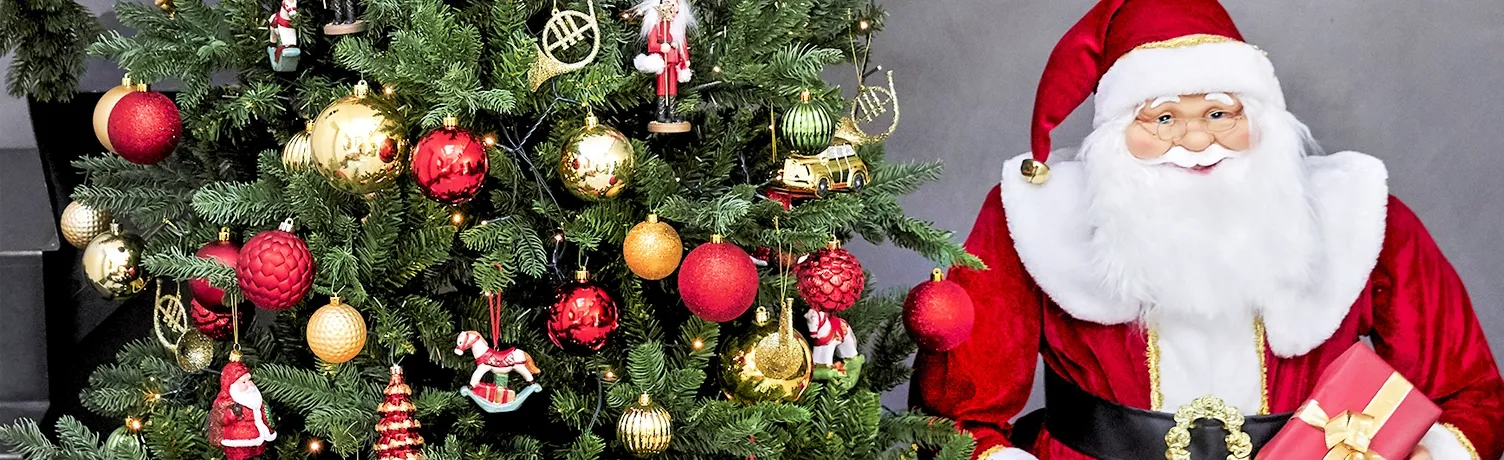 kunstig juletræ med rød og guld pynt, og kunstig julemand ved siden af