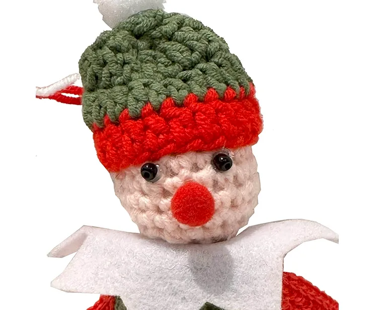 Juletræspynt fin hæklet nisse med rødt og grønt tøj closeup