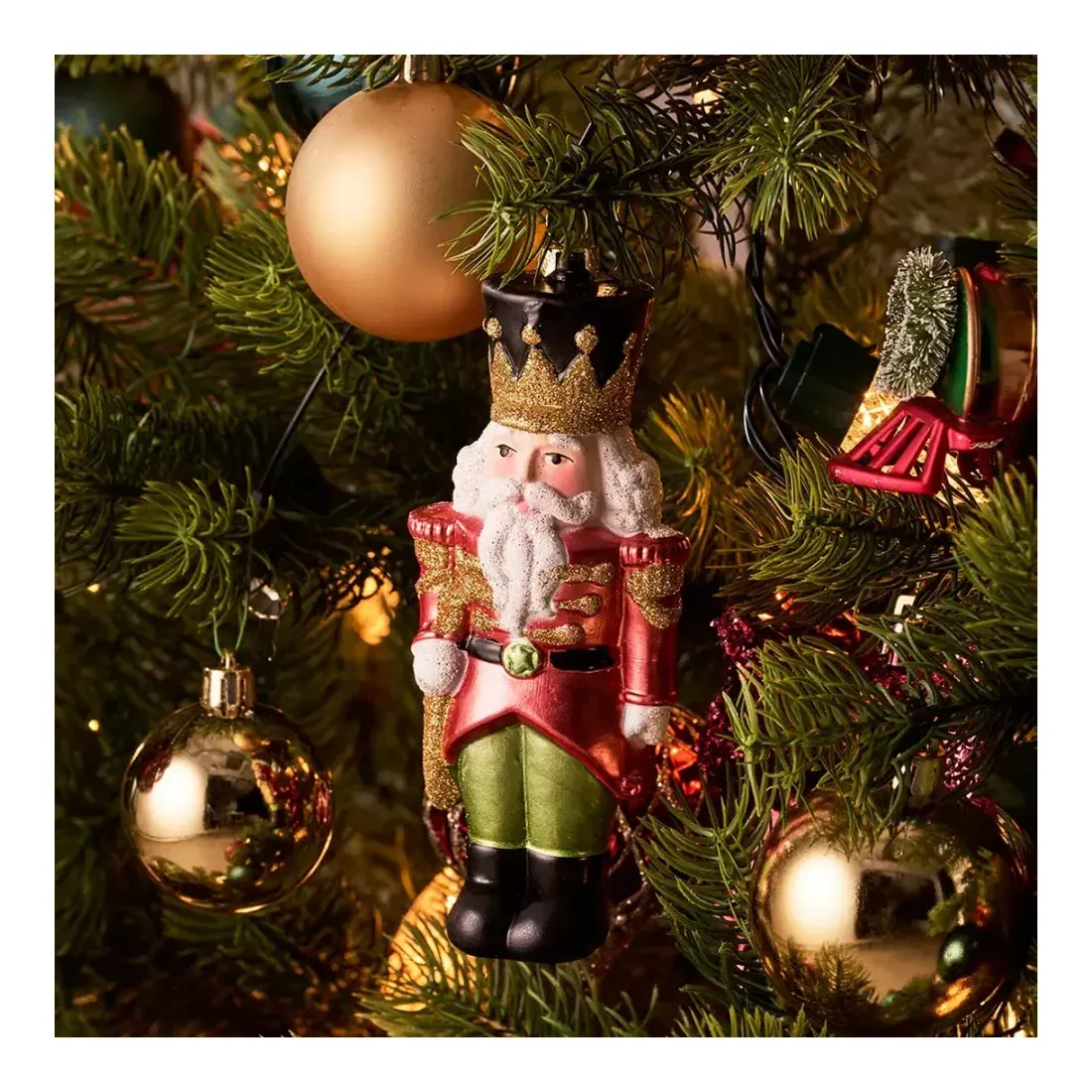 Soldat af plast i rød og grøn juletræspynt 15cm vist på kunstig juletræ