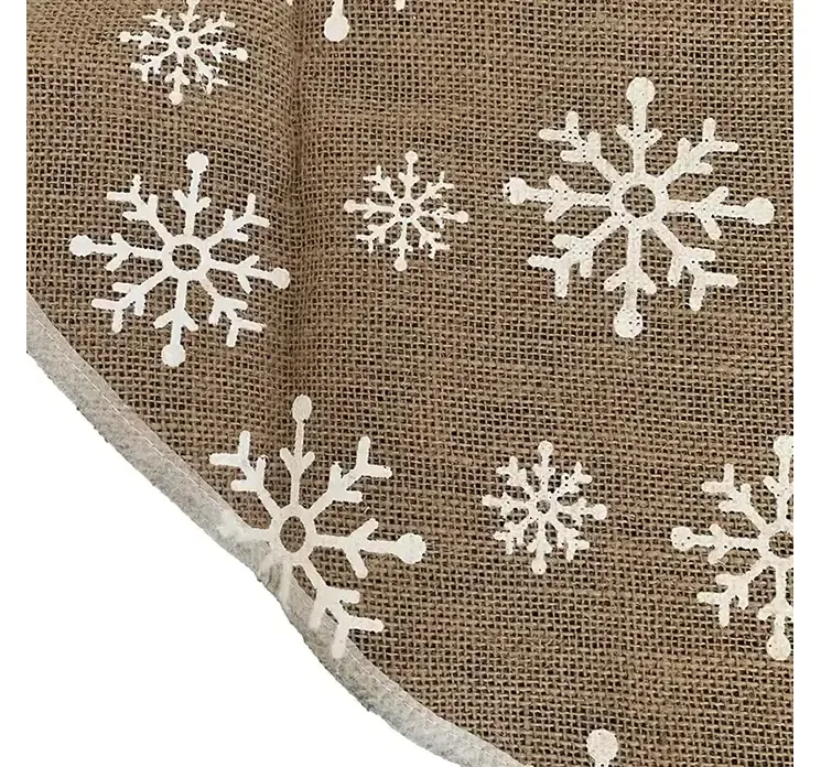 Juletræstæppe rundt i naturfarvet stof med små hvide snefnug closeup