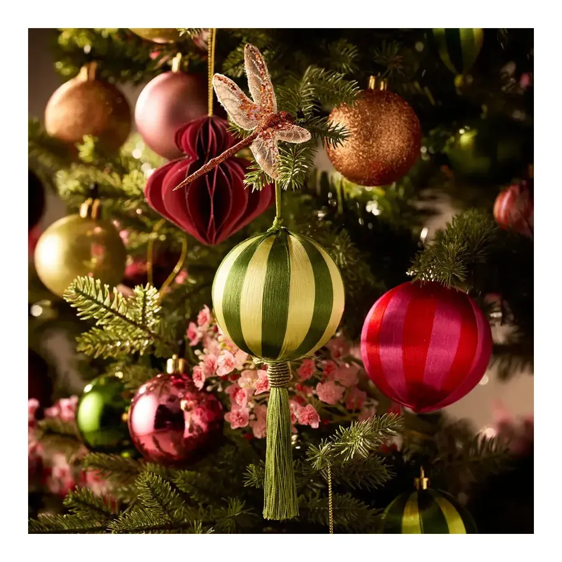 Julekugler med striber og ornament af papir vist på kunstig juletræ