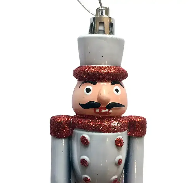 Nøddeknækker i hvid og rød af plast med ophæng julepynt closeup