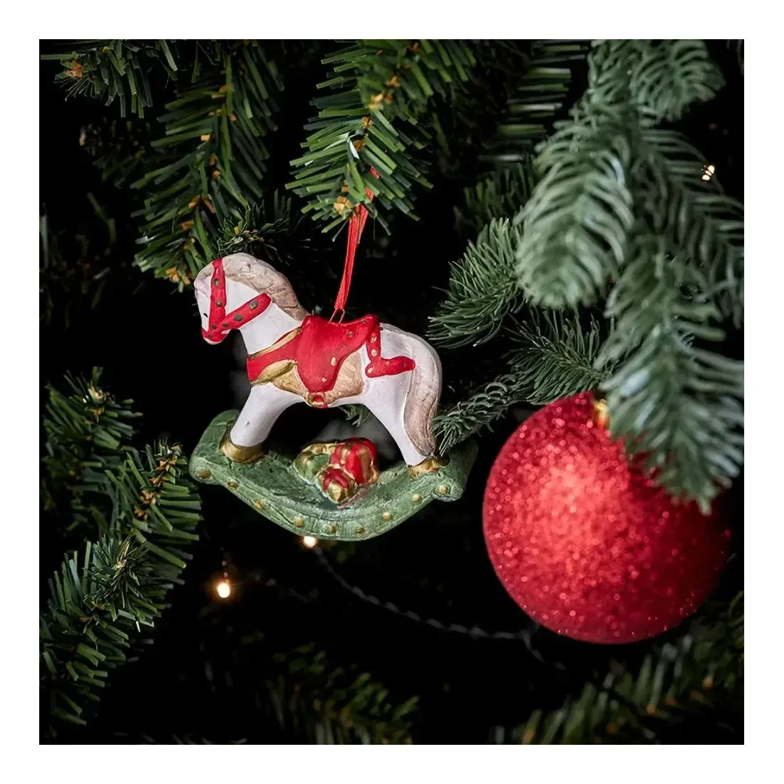Gyngehest julepynt af keramik i flere farver og ophæng vist hængt op på juletræ