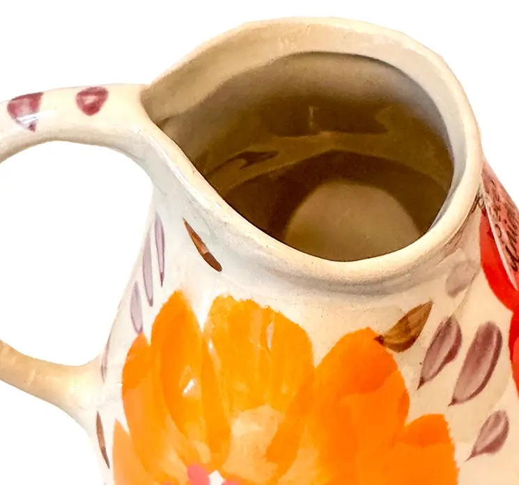 Vase af håndlavet keramik med hank og påmalede blomster i multifarver closeup