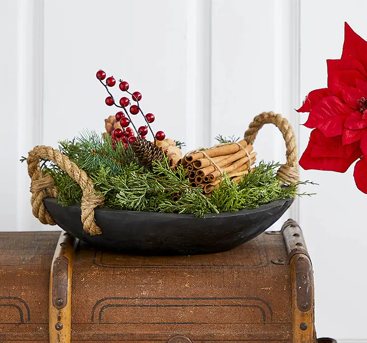 Fad af teaktræ i sort med håndtag af reb vist med kunstig gran og kanel bundt i julearrangement