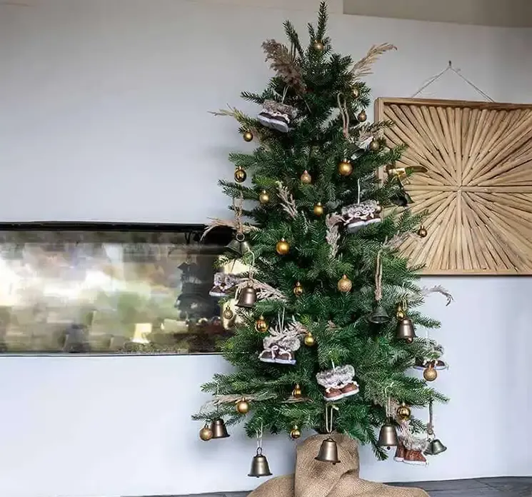 julekugler af plast i guldfarvet, mat, blank og med glimmer vist på juletræ i miljø
