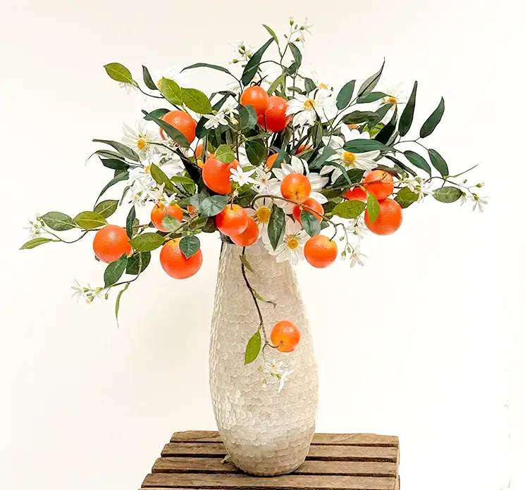 Appelsin gren med orange appelsiner sat sammen med hvide margueritter i en vase kunstige grene og blomster