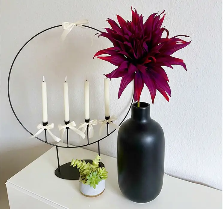 Dahlia også kaldet georgine kunstig blomst af plast i lilla vist i sort vase i stuemiljø