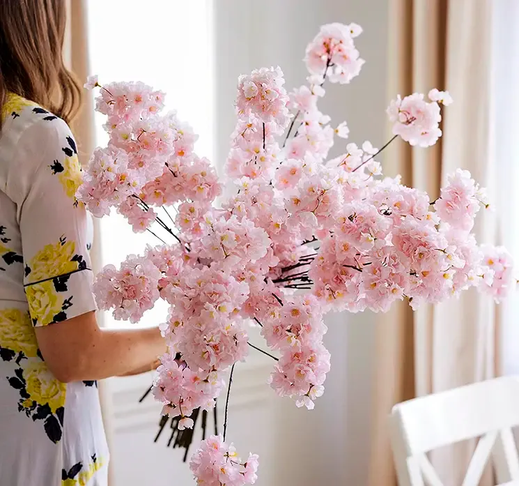 kunstige kirsebær grene af plast i lyserøde sat sammen til en stor buket i mijlø