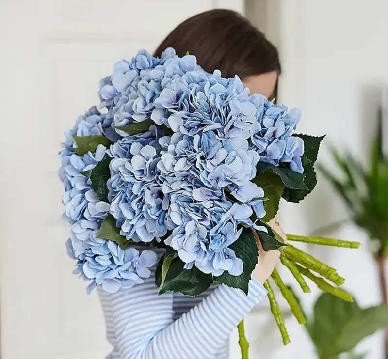 Kunstig blomst hortensia i blå sat sammen i en stor buket