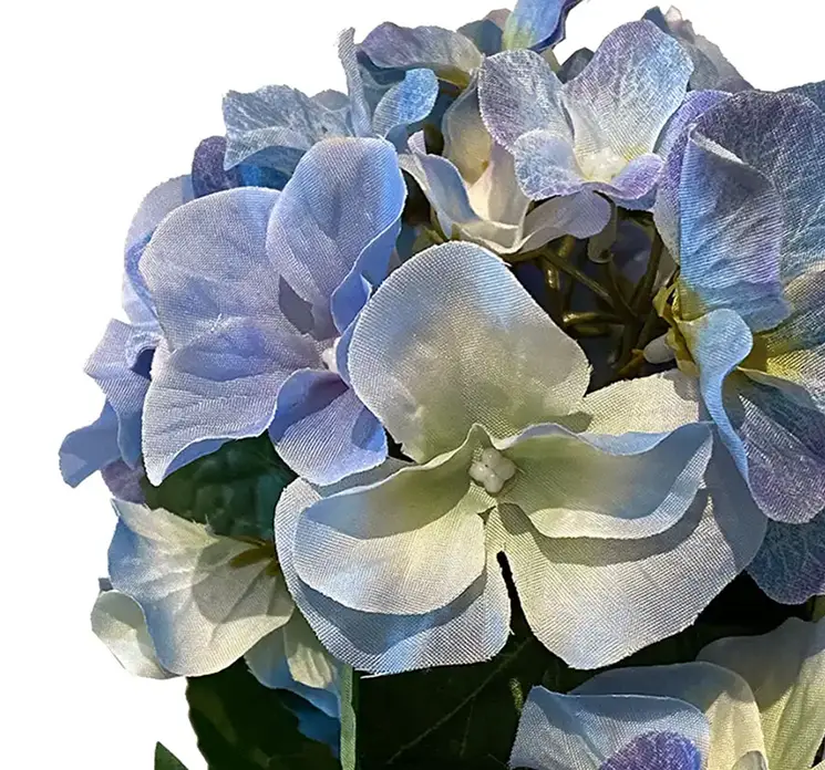 Hortensia kunstig blomst af plast i blå sat i flettet kurv af rattan closeup af blomst