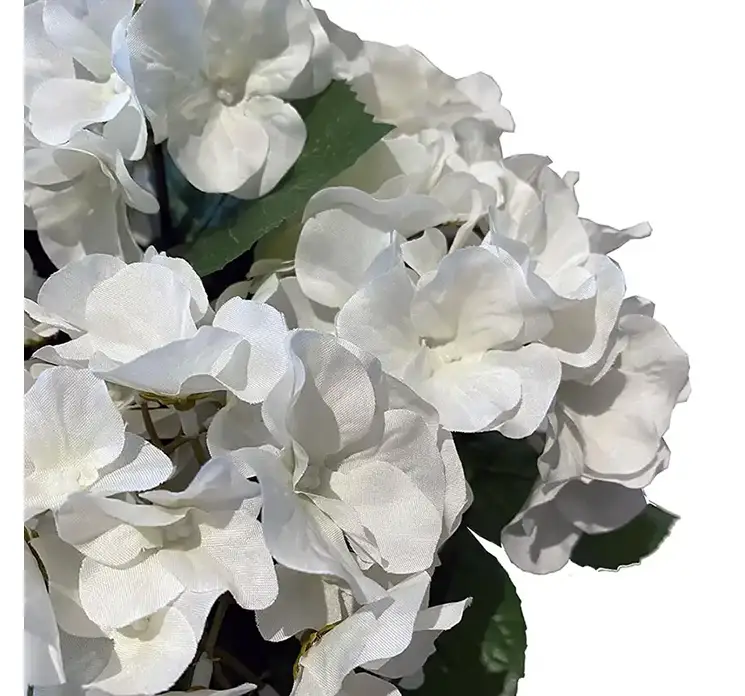 Hortensia kunstig blomst af plast i hvid sat i en flettet kurv af rattan closeup af blomsten
