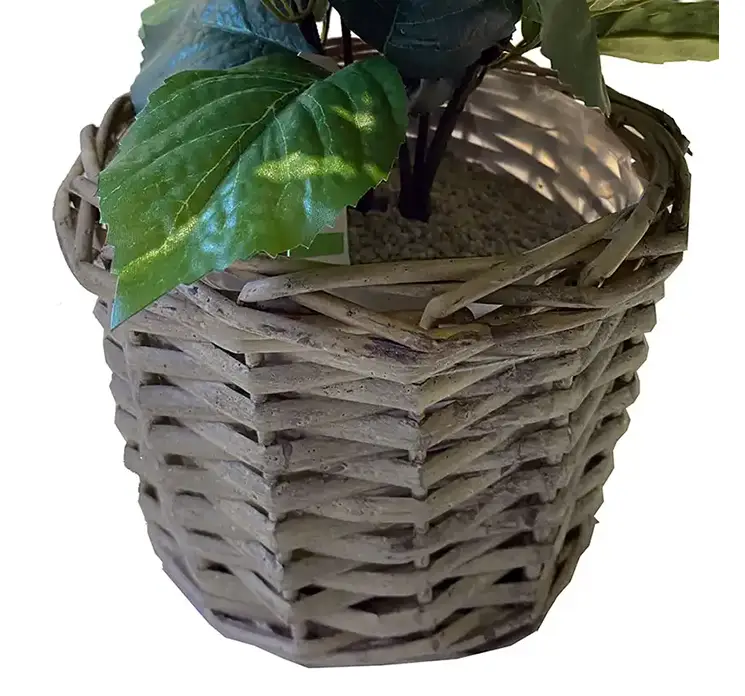Hortensia kunstig blomst af plast i hvid sat i en flettet kurv af rattan closeup af kurven