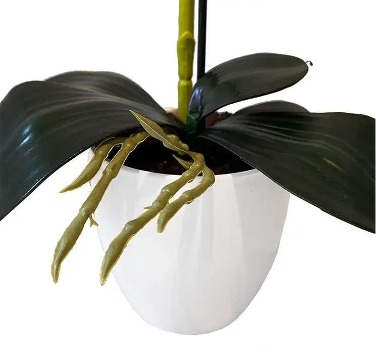 Kunstig orkide i hvid potte af plast, pink farvet closeup